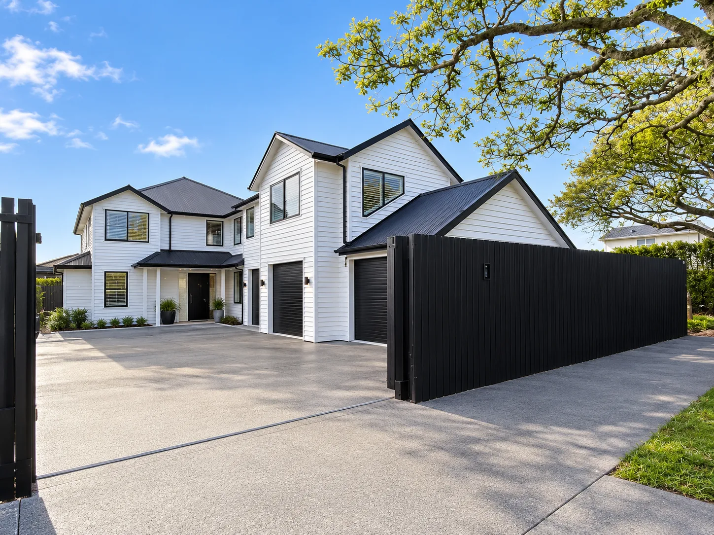 The new two-storey home on the same section, with internal garaging and a gated driveway