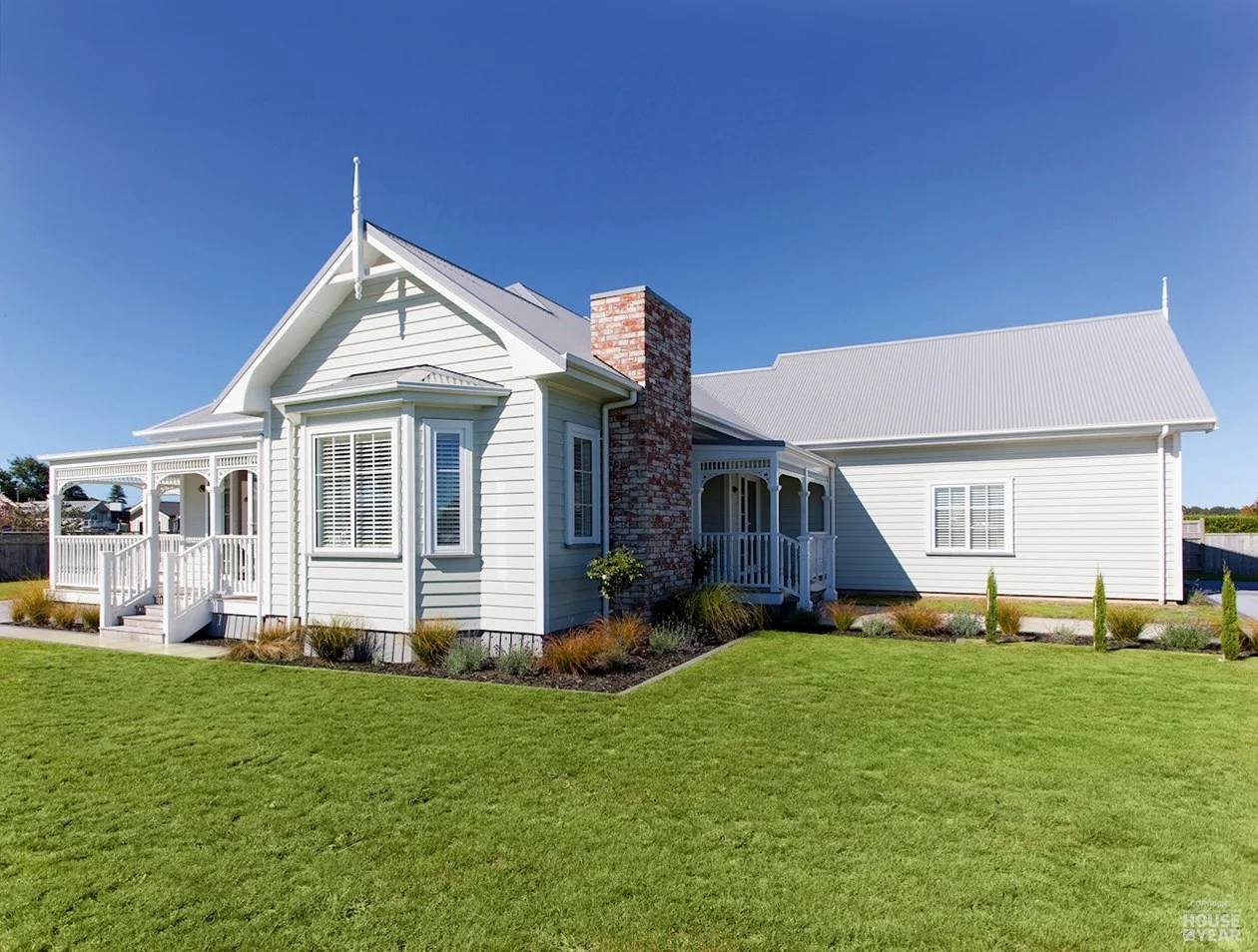 A new villa-style Navigation home with a wraparound verandah, bay window and brick chimney